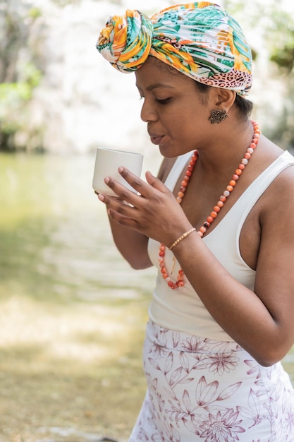 Woman drinking coffee by the river