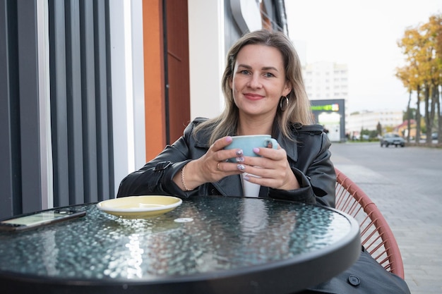 Woman drinking coffee in a cafe outdoors