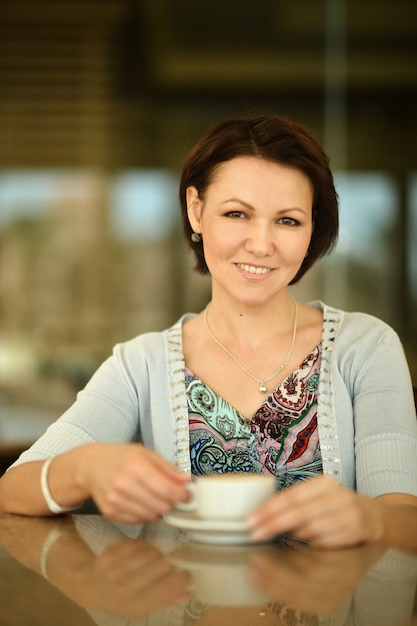 Woman drinking a coffee from a cup in a restaurant