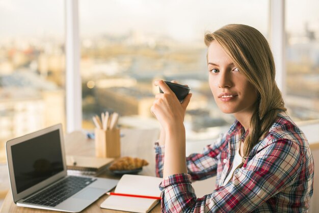 Woman drinking coffee in office