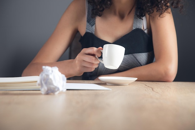 Woman drinking coffee in working table