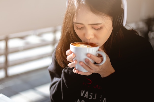 woman drinking a hot coffee and listening to music in vacation and relaxing