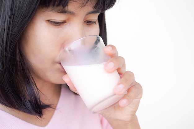 Woman drinking milk from glass close up on white bakcground. Portrait  authentic skin tan asian lady. fast food for good health in morning and before bedtime. high protein food.