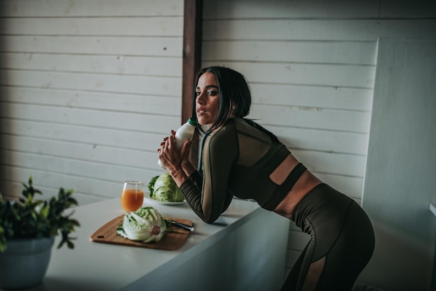 Woman drinking milk in kitchen at home