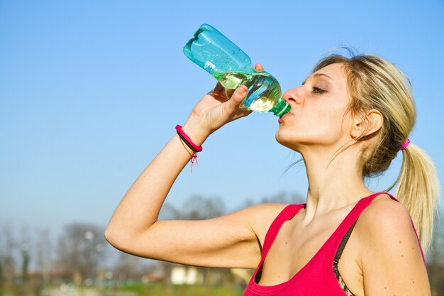 woman drinking water from bottle after fitness sport exercise 