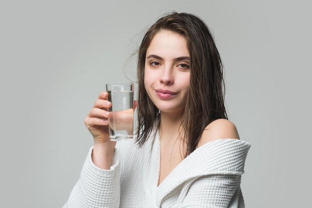 Woman drinking water glass. Beautiful woman, female skin care, close up face beauty portrait.