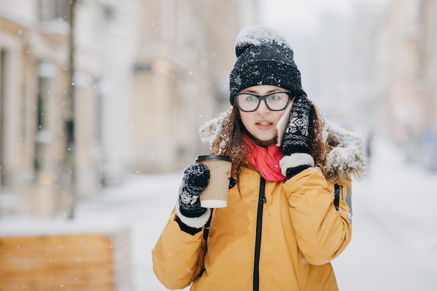 Woman Drinks Coffee and Talking on the Phone Outdoors