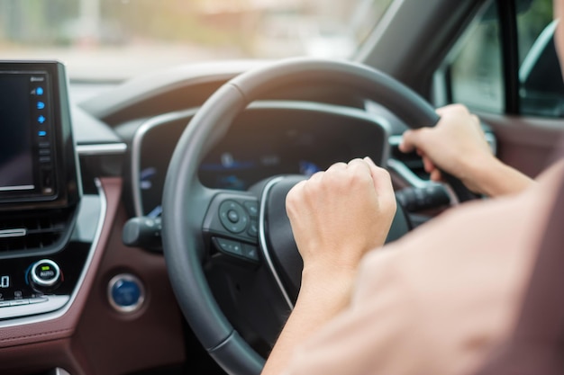 Woman driver honking a car during driving on traffic road hand controlling steering wheel in vehicle Journey trip and safety Transportation concepts