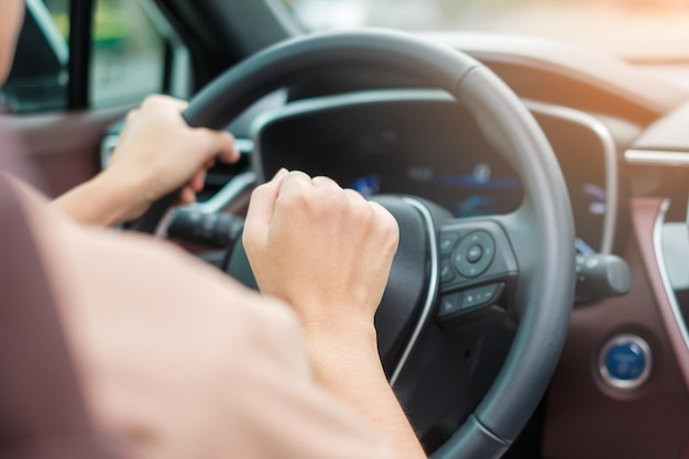 Woman driver honking a car during driving on traffic road hand controlling steering wheel in vehicle Journey trip and safety Transportation concepts