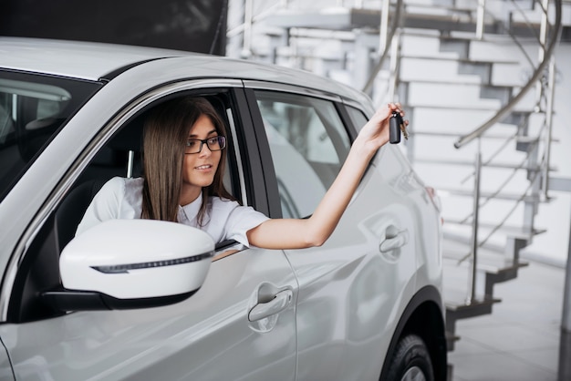 The woman driver smiling showing new car keys