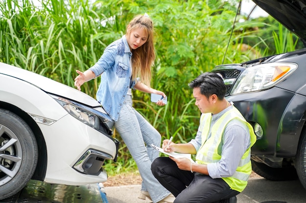 Woman drivers demented after the car crashed with insurance company officer checking car damages on country road