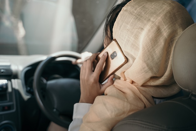 Woman driving car while having phone call