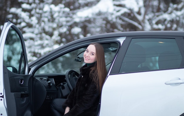 A woman driving a car in winter Winter car driving by a woman