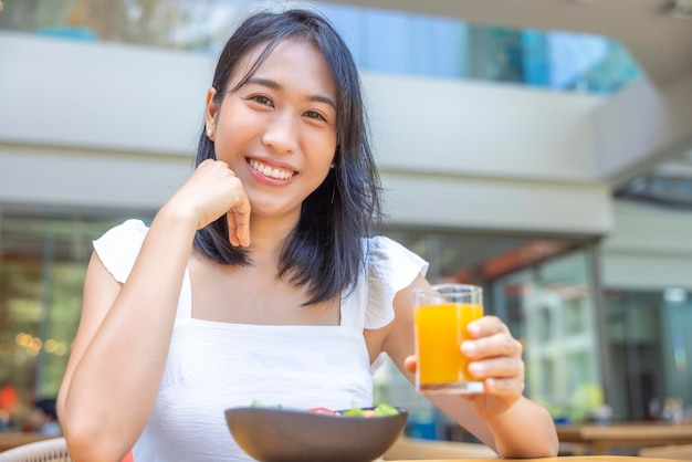 Woman eating Breakfast Fruits such as watermelon papaya melon passion fruit orange juice and coffee