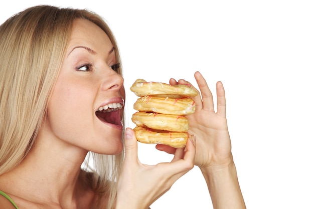 Woman eating a cake on a white wall