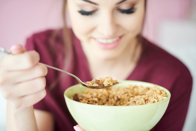 Woman eating cereal in bowl