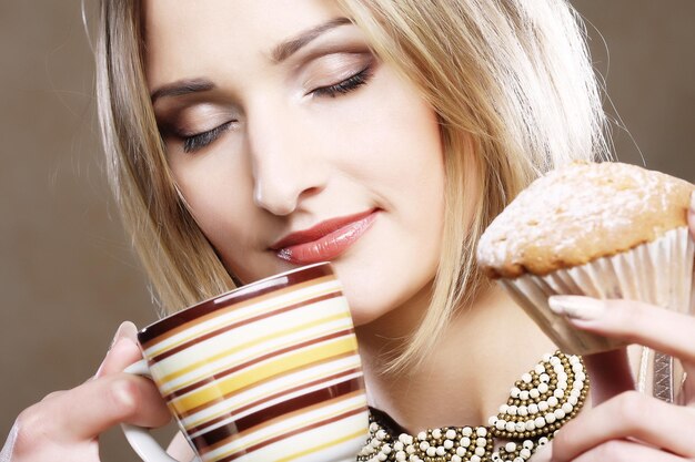 Woman eating cookie and drinking coffee