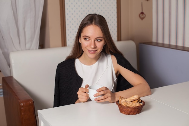 Woman eating cookies and drinking hot tea in cafe