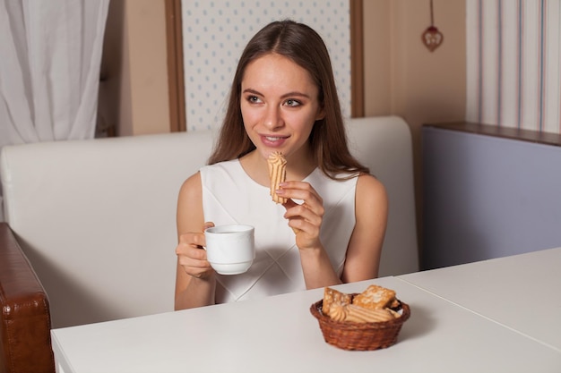 Woman eating cookies and drinking hot tea in cafe