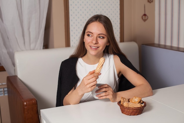 Woman eating cookies and drinking hot tea in cafe