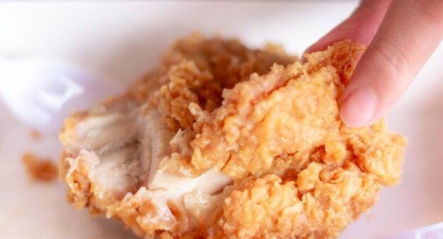 Woman eating fried chicken blurred background