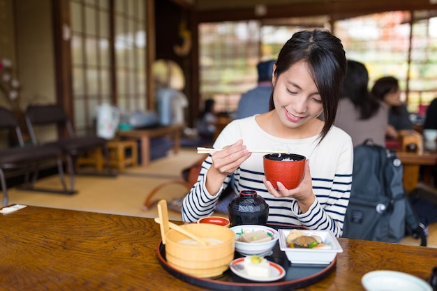 Woman eating in Japanese restaurant