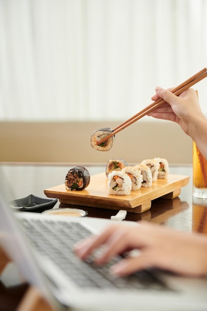 Woman Eating Sushi when Working