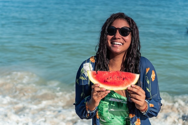 Woman eating watermelon on the beach