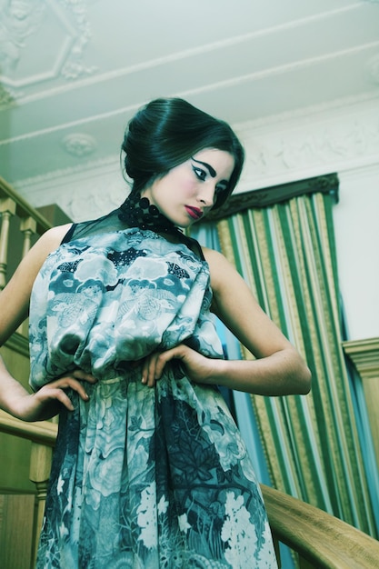 Woman in elegant dress posing on stairs