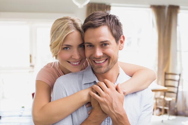 Woman embracing man from behind at home