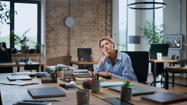 Photo woman employee bored office coworking alone closeup weary businesswoman work