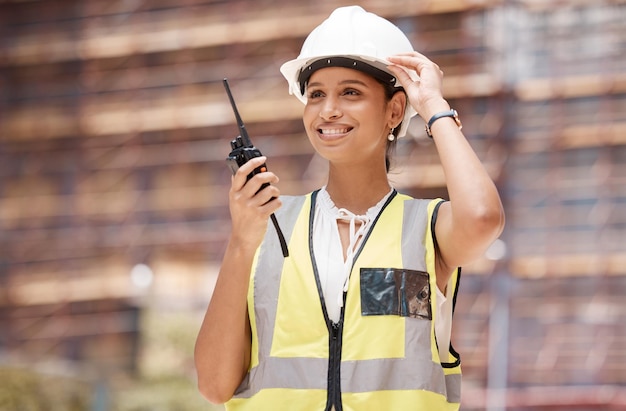 Woman engineer construction and communication with walkie talkie technology and safety check working Construction worker industry and protection helmet radio supervision and leadership