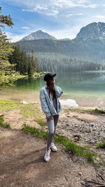 Woman enjoying beauty of nature looking at mountain lake in Montenegro