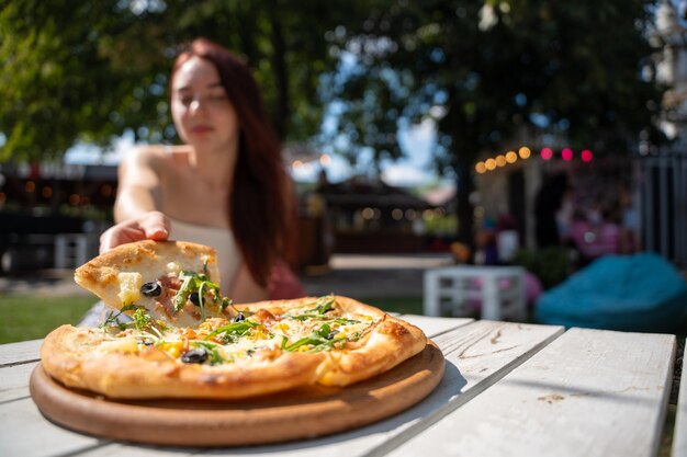 Woman Enjoying Fresh Pizza in an Outdoor Setting