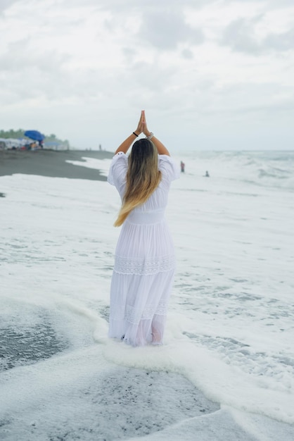 Woman enjoying herself on the seashore on the coast of the pacific ocean. Cloudy day.