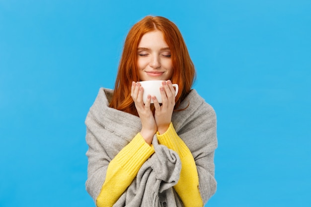 woman enjoying nice hot cup of coffee smelling flavour with closed eyes and delighted