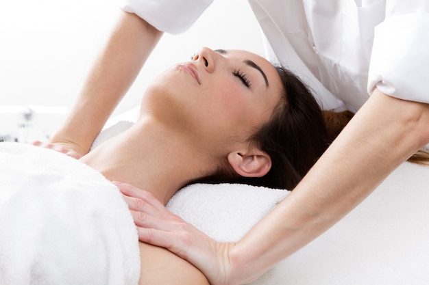 Woman enjoying shoulder massage at beauty spa