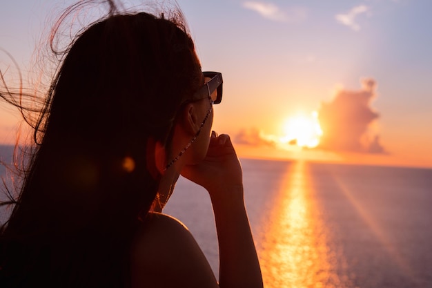 Woman enjoying sunset above the sea summertime vacation