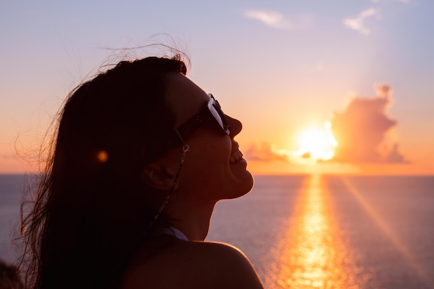 Woman enjoying sunset above the sea summertime vacation