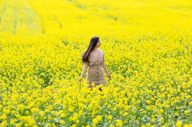 woman enjoying time in the middle of a field of yellow flowers