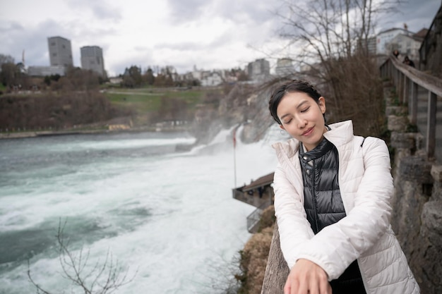 Woman enjoying view of Rhine falls during winter season in Switzerland