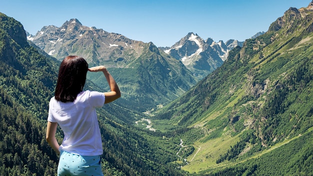 Woman enjoys a beautiful view of the mountains and blue sky from a height