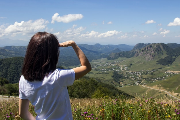 Woman enjoys a beautiful view of village in the mountains Travel tourism adventure love for nature concept