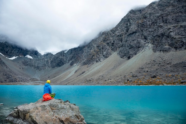 Woman enjoys Blaisvatnet blue lake in the mountains of the Lyngen Alps Lyngenfjord Norway