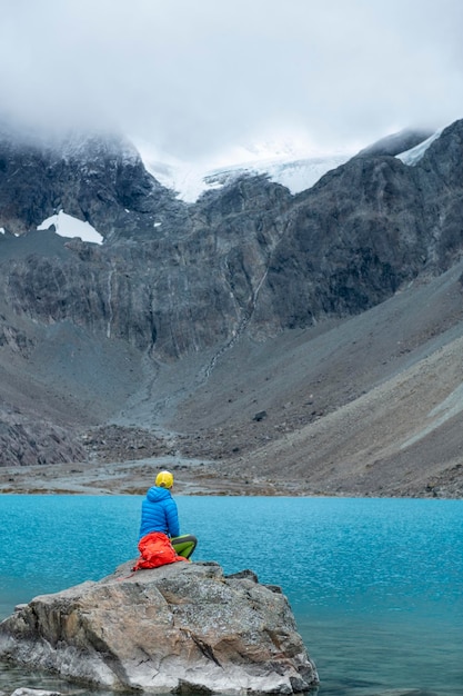 Woman enjoys Blaisvatnet Blue lake with mountains of the Lyngen Alps Lyngenfjord  Norway