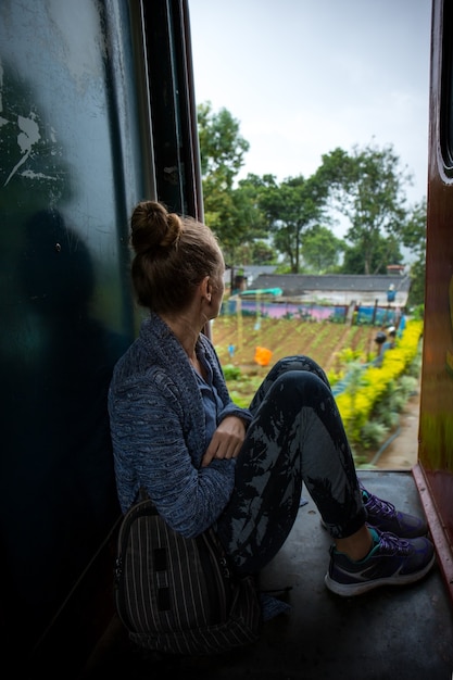 A woman enjoys nature traveling in a train on Sri Lanka