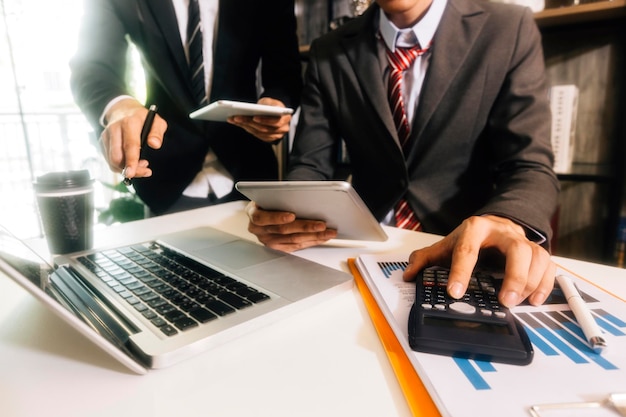 Woman entrepreneur using a calculator with a pen in her hand calculating financial expense at home office