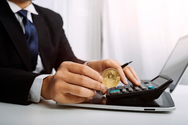 Woman entrepreneur using a calculator with a pen in her hand calculating financial expense at home office