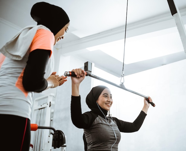 Woman exercising and getting supported by her trainer and friend