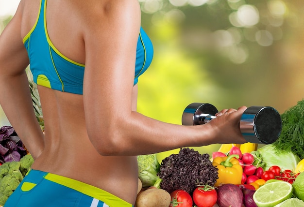 Woman exercising with dumbbell on background